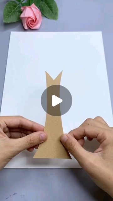 two hands holding up a piece of paper with the shape of a tree on it