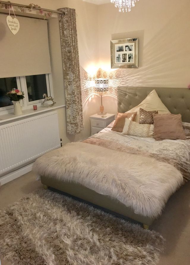 a bedroom with a large bed and chandelier hanging from it's ceiling