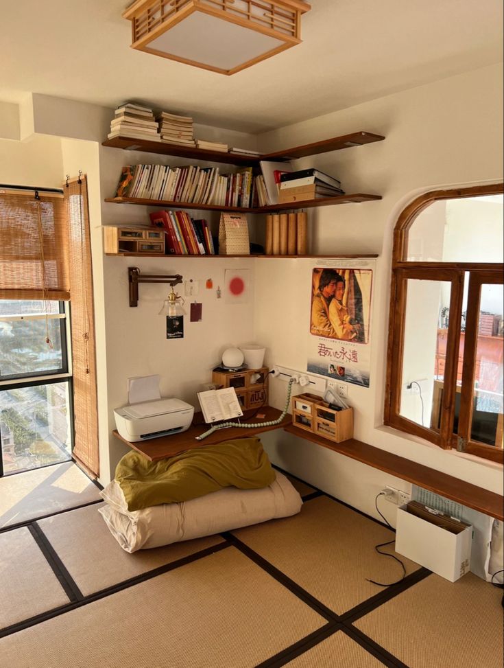 a room with a bed, desk and bookshelf on the wall above it