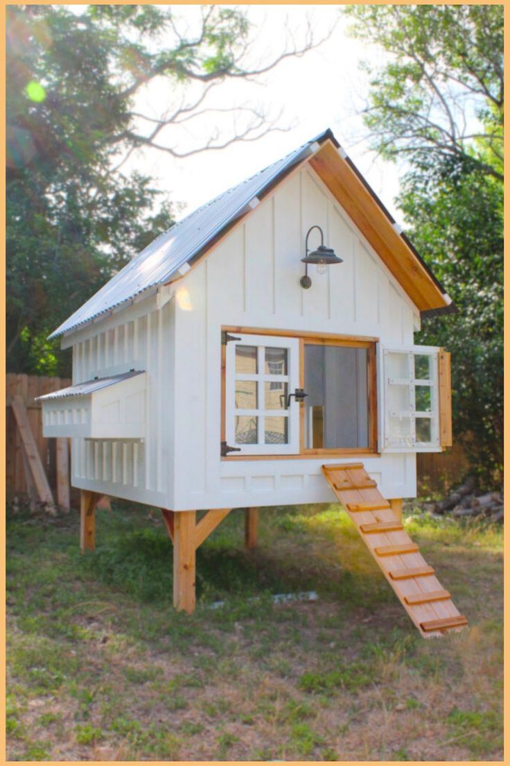 a small white house sitting in the middle of a field with stairs leading up to it