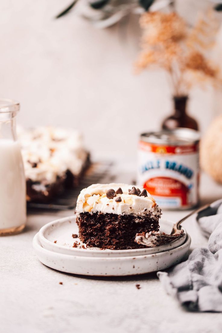 a piece of cake sitting on top of a plate next to a bottle of milk