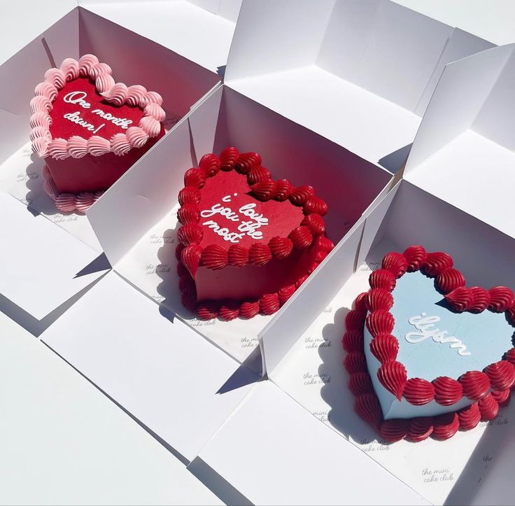 three heart shaped cakes in boxes on display