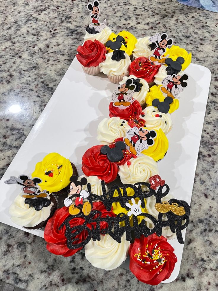 mickey mouse cupcakes are arranged on a white plate