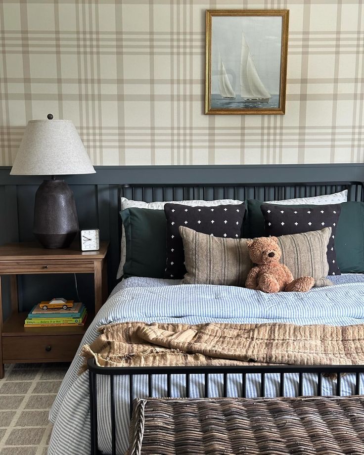 a teddy bear sitting on top of a bed next to a night stand and lamp