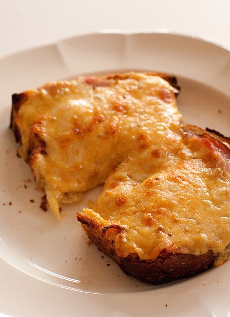 a white plate topped with cheesy bread on top of a table