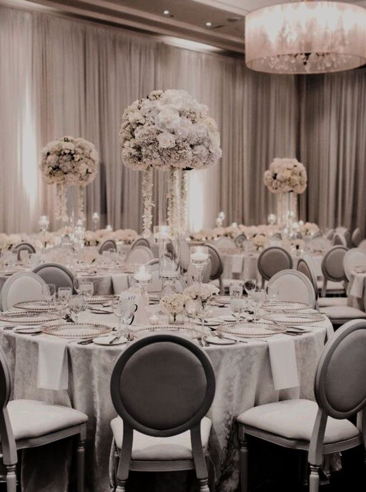 the tables are set with white and silver linens for an elegant wedding reception at the sheraton