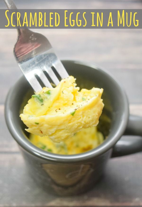 scrambled eggs in a mug with a fork sticking out of the cup and text overlay that reads scrambled eggs in a mug