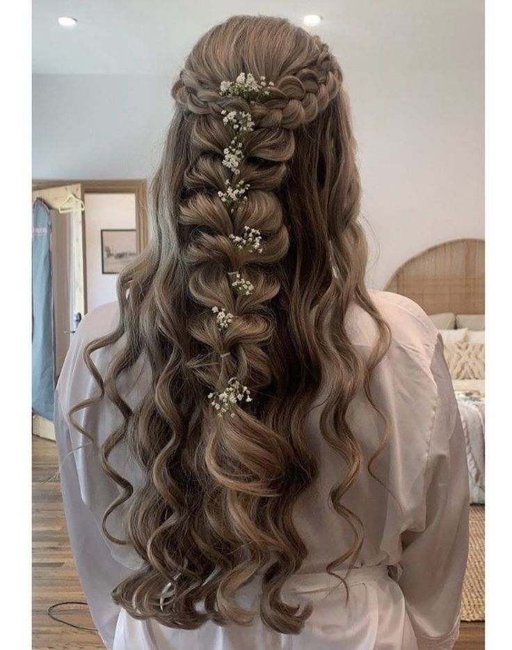 the back of a woman's head with long hair and flowers in her hair