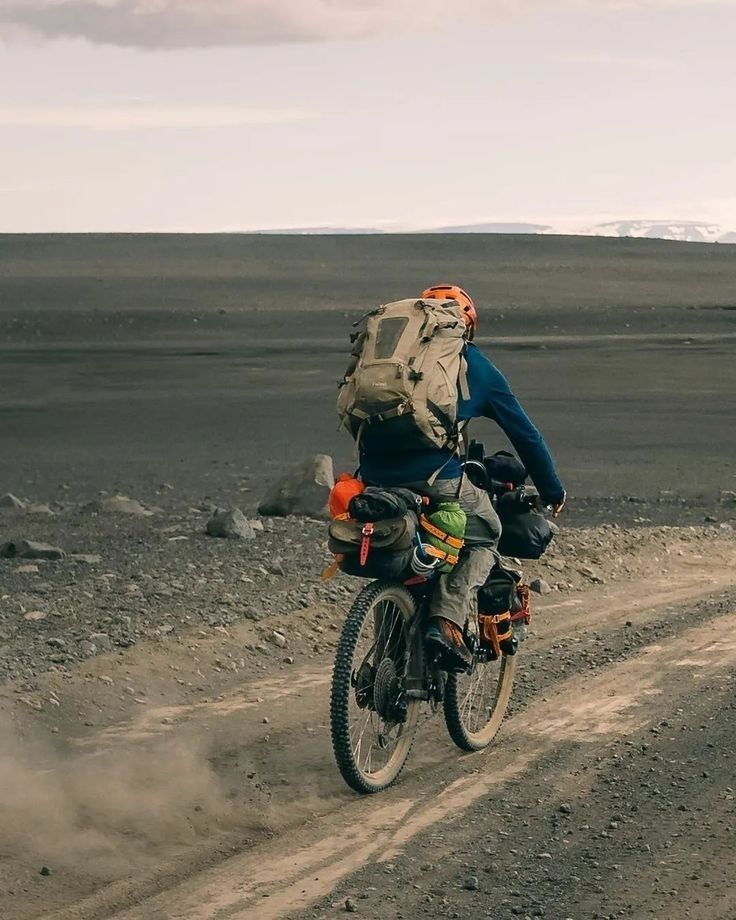 a man riding a motorcycle down a dirt road