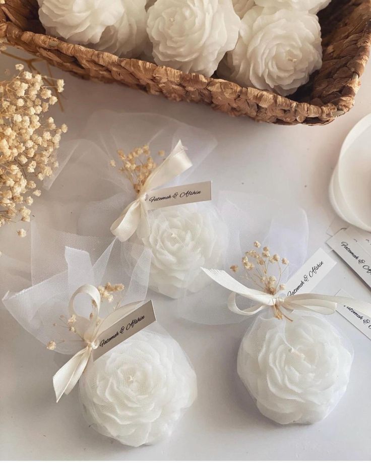 some white flowers are sitting on the table next to each other and tags in front of them