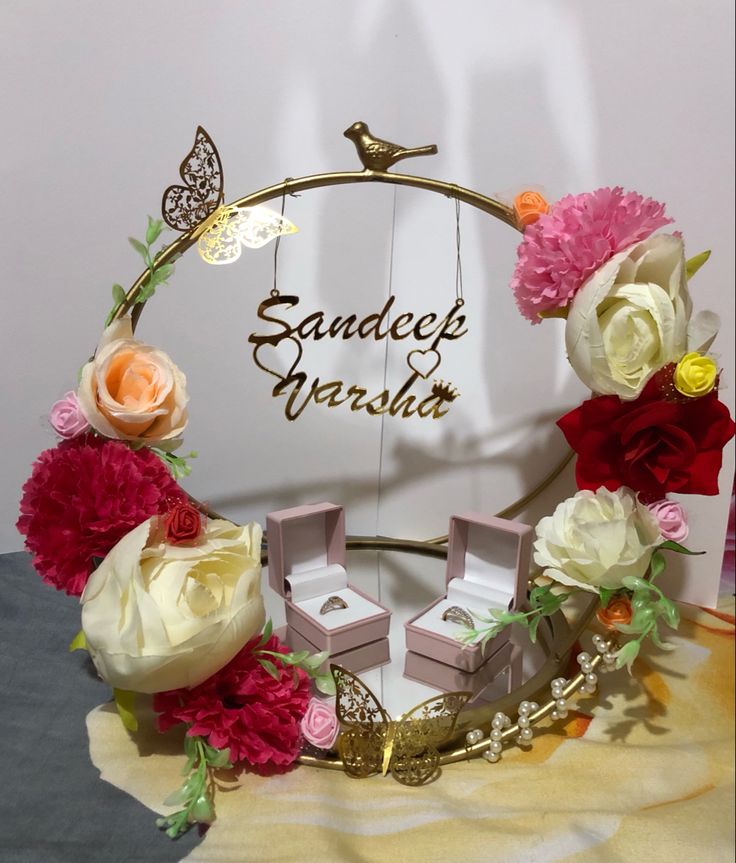 an arrangement of flowers and jewelry is displayed in front of a sign that says sandee mersida