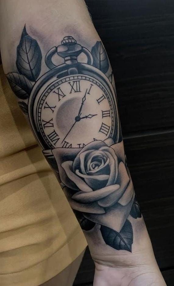 a woman's arm with a clock and rose tattoo on the wrist, in black and white