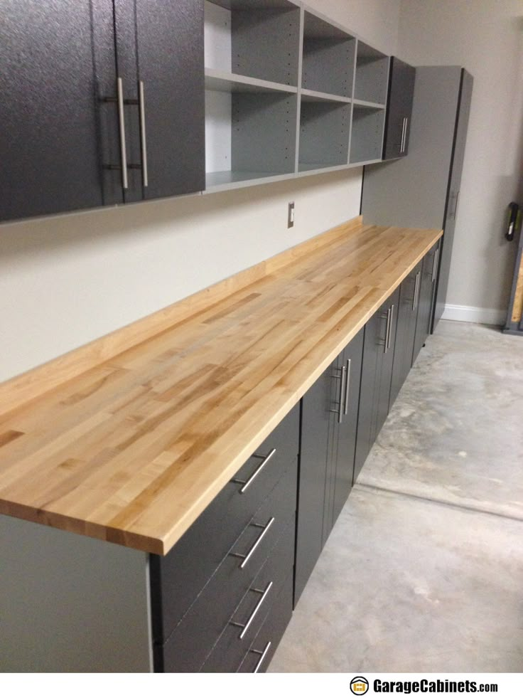 an unfinished counter top in the middle of a room with cabinets and shelves on both sides