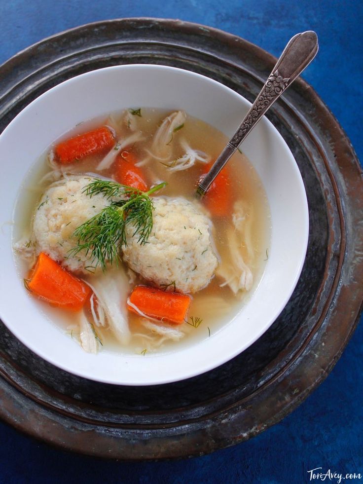 a bowl of soup with dumplings and carrots