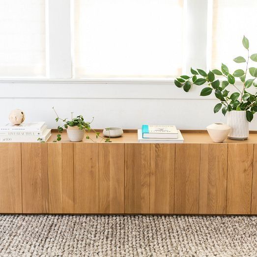 a wooden shelf with plants and books on it