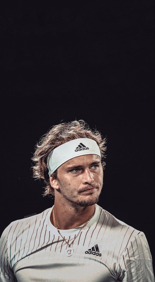 a man with a tennis racket in his hand and wearing a white headband