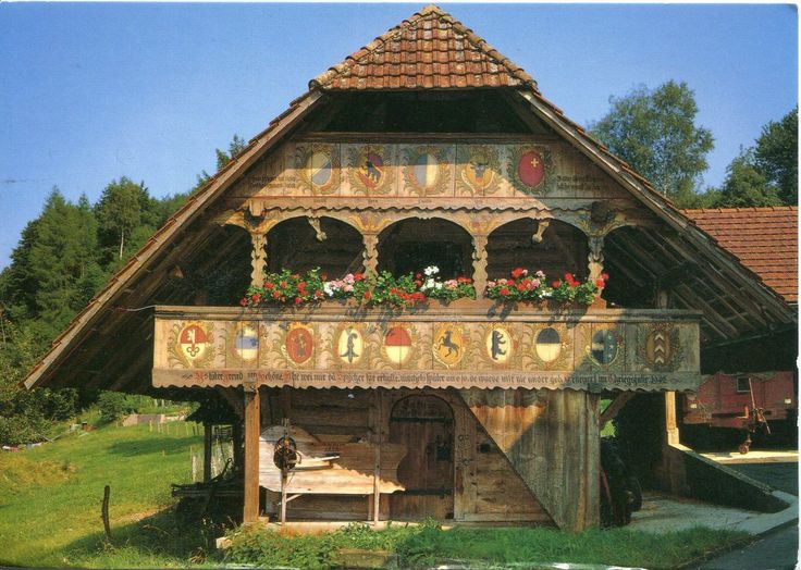 an old wooden building in the middle of a field