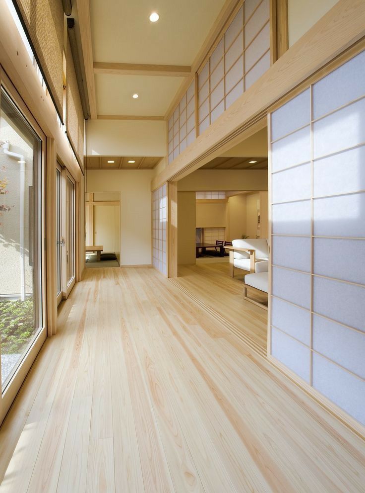 an empty room with wood flooring and white wall covering the walls, along with sliding glass doors