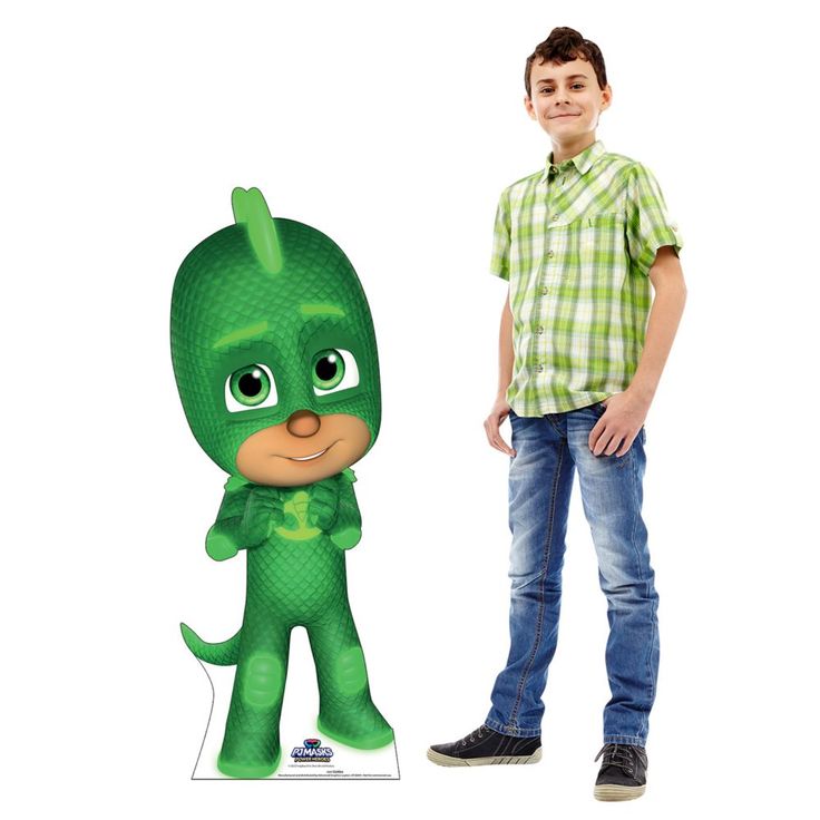 a young boy standing next to a cardboard cutout of the pj masks character