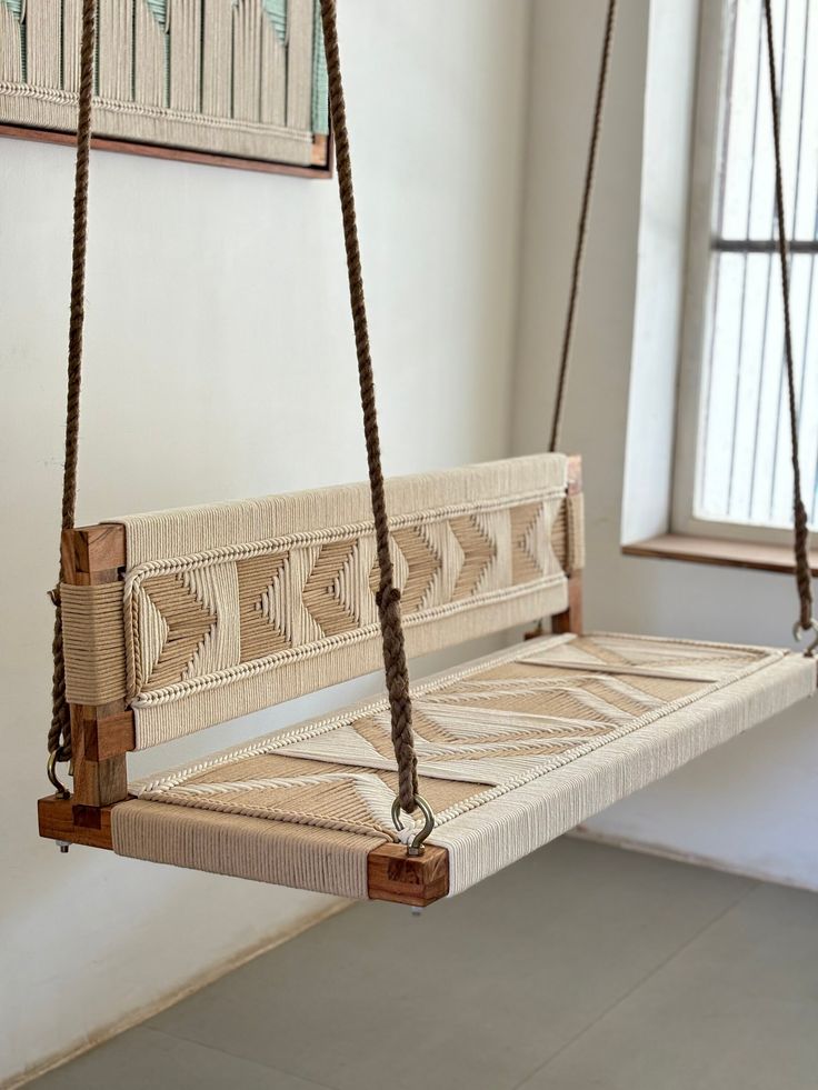 a wooden swing hanging from the ceiling in a room