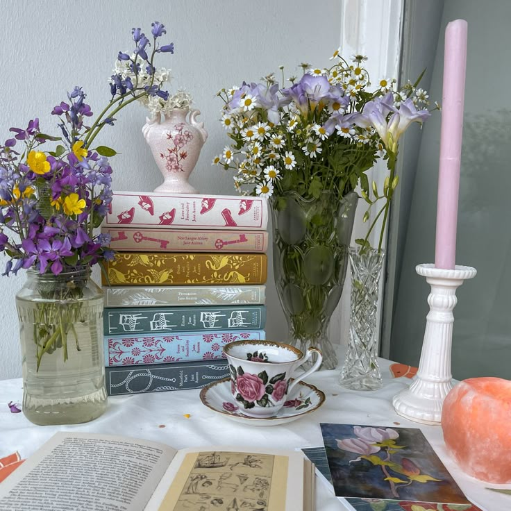 a table topped with books and vases filled with flowers