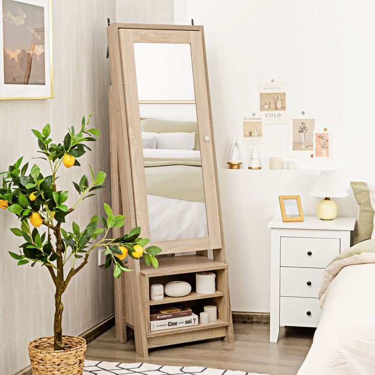 a mirror sitting on top of a wooden shelf next to a plant in a vase