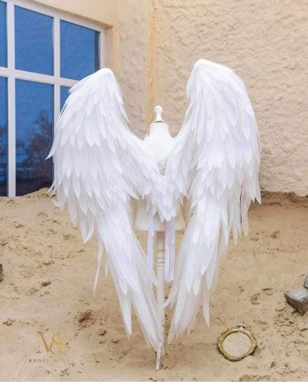 white angel wings sitting on top of a fire hydrant