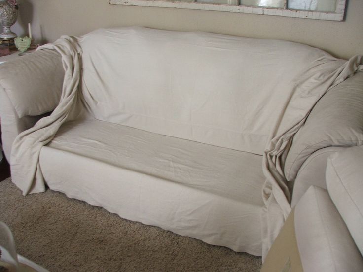 a white couch covered with a blanket in a living room