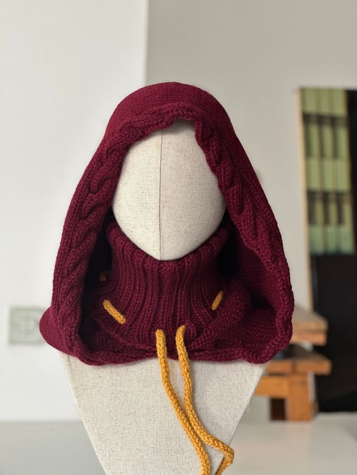 Magical hood knitted by hand with vegan  burgundy acrylic yarn. One size! The main color and the secondary color (the color of the cord) is customizable. Oat color: https://etsy.me/3RC2tQ9 Black color: https://etsy.me/3xIZbT7 Green color: https://etsy.me/3xIfKhT Write me if you need a different color! Unique Hats Fashion, Wizard Hat Crochet Pattern, Knitted Witch Hat, Crochet Fantasy Hat, Crochet Fae Elf Hood Free Pattern, Crochet Hedge Witch Hat, Wizard Hats, Crochet Fantasy Hood, Oat Color