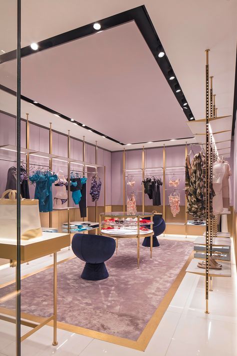 the interior of a clothing store with purple and gold accents