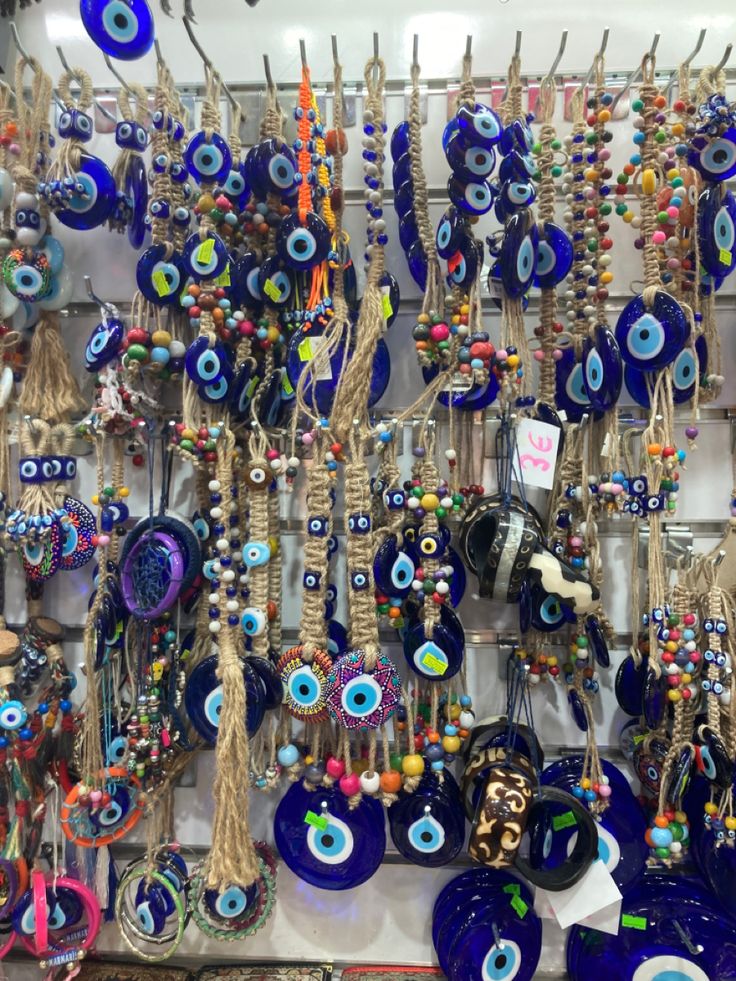 an assortment of evil eye glass and bead necklaces on display in a store