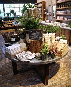 a table filled with lots of different types of plants and food on display in a store