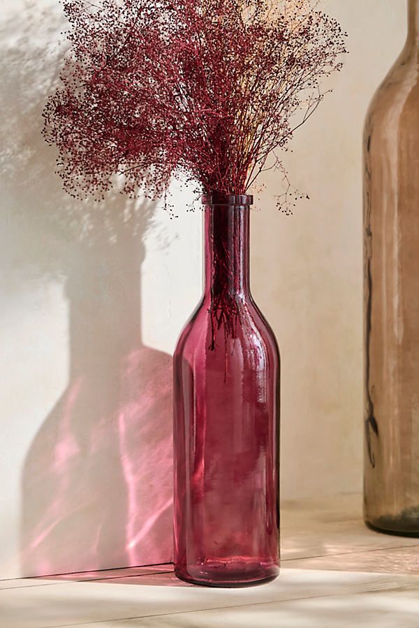 two vases with dried flowers in them on a table next to each other,