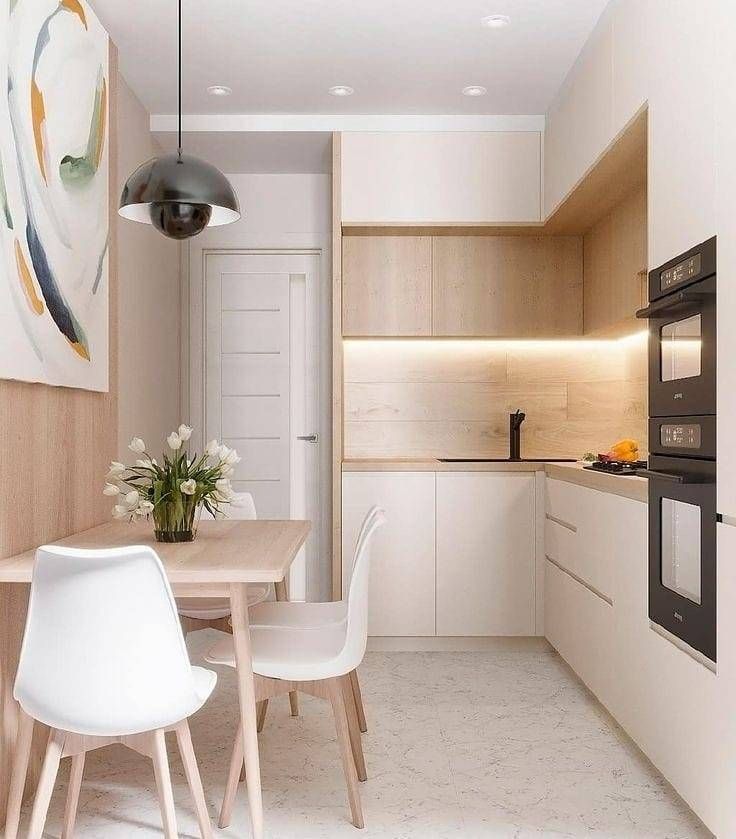 a modern kitchen with white chairs and wood accents on the walls, along with a dining table