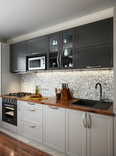 a kitchen with gray cabinets and wood floors