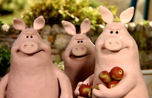 three pigs are holding apples in their hands