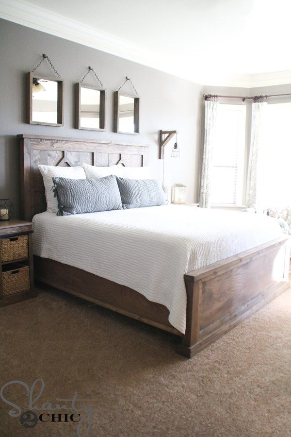 a bedroom with a large bed and two mirrors on the wall