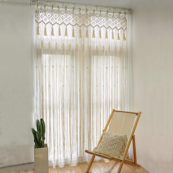 a chair sitting in front of a window next to a potted plant on top of a hard wood floor