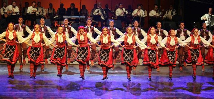 a group of people that are standing on a stage with some kind of dance costume