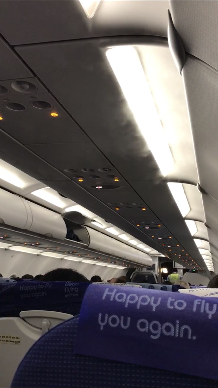 the inside of an airplane that is happy to fly you again sign on the ceiling