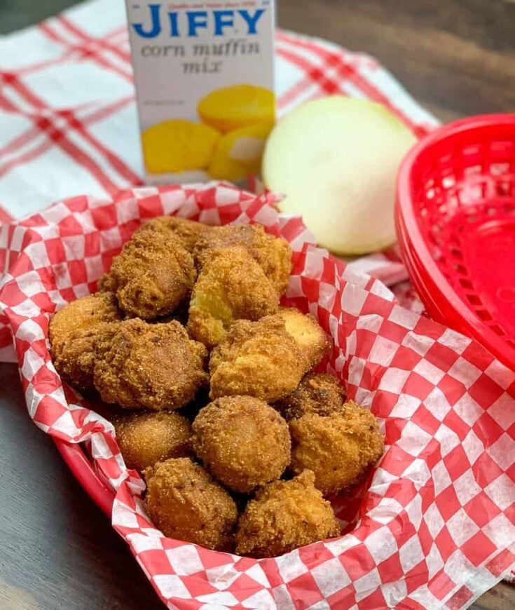 a basket filled with fried food next to a container of yogurt