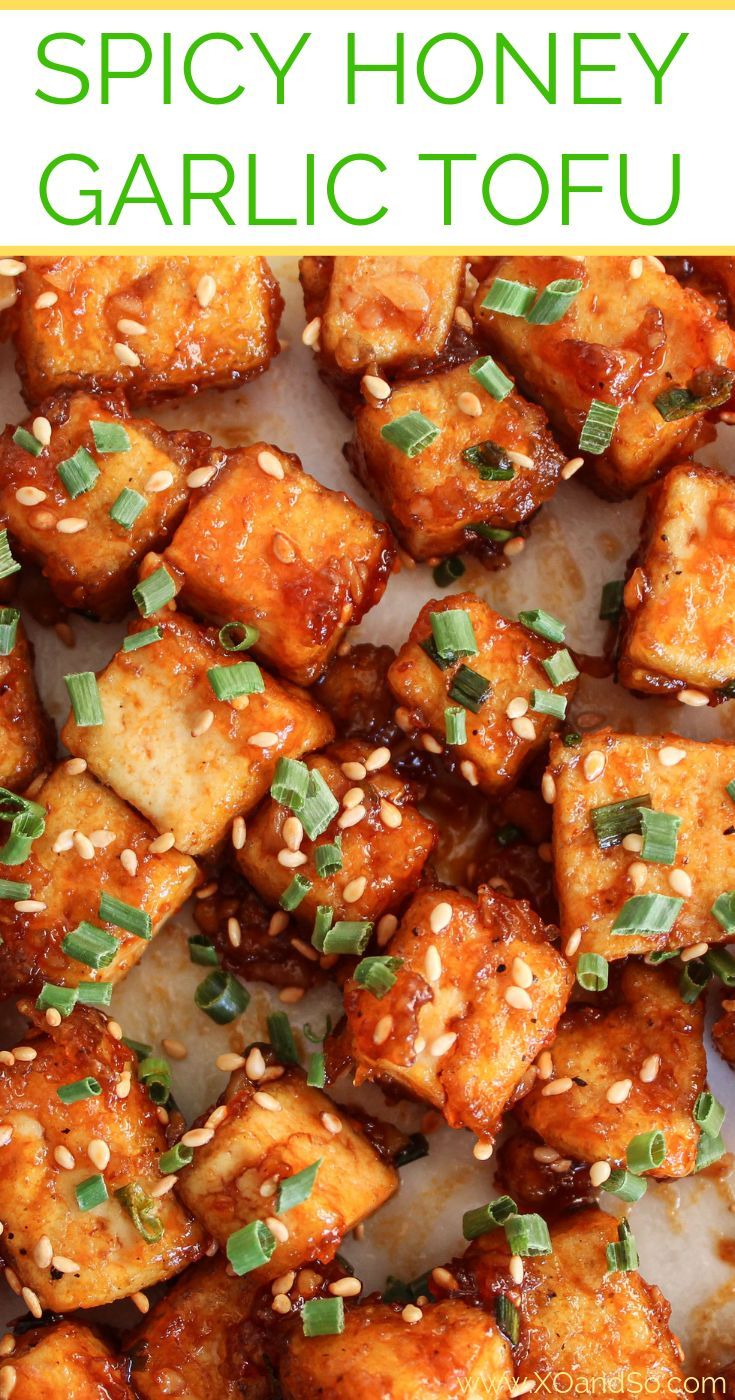 spicy honey garlic tofu on a plate with sesame seeds and green garnish