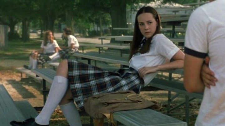 a woman sitting on top of a bench next to a man in a white shirt