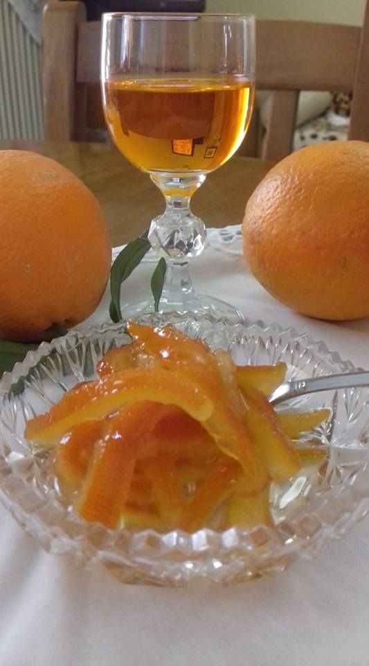 two oranges are sitting on a table next to wine glasses and an orange peel