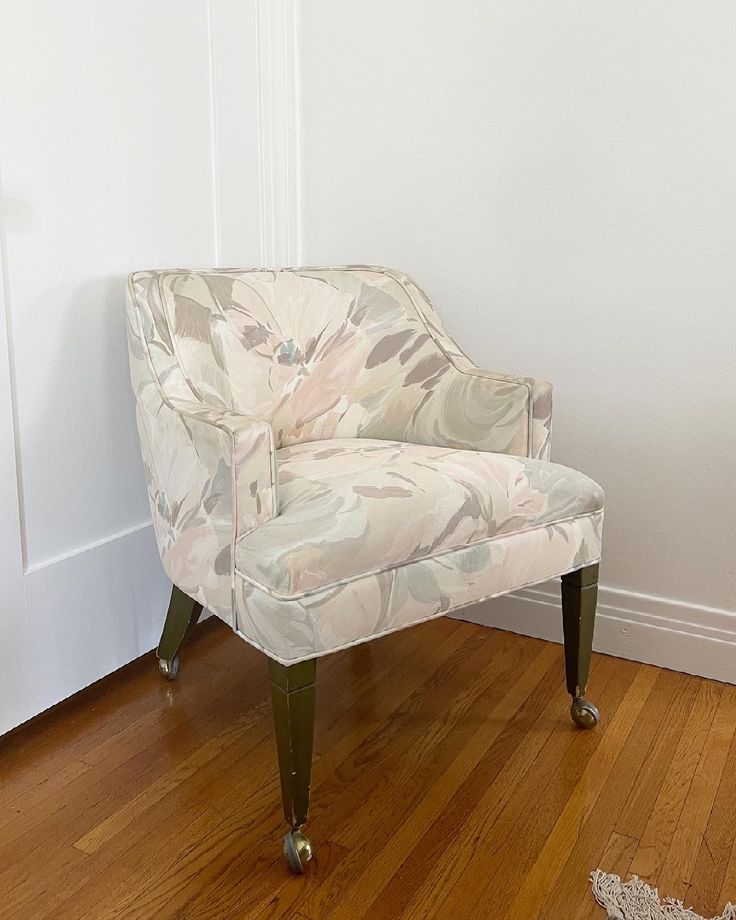 a chair sitting on top of a hard wood floor next to a white painted wall