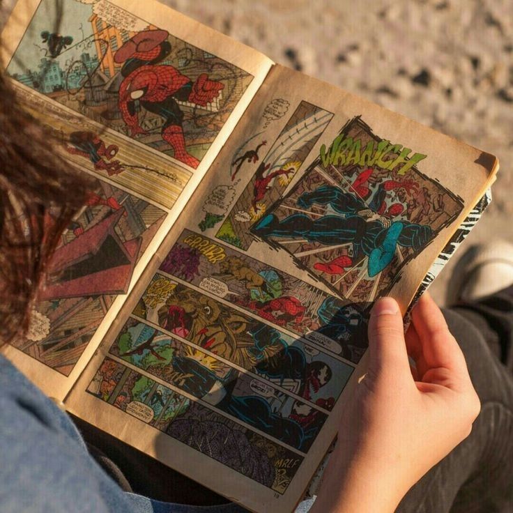 a person is holding an open comic book