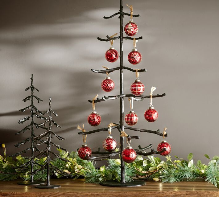 a christmas tree with ornaments hanging from it's branches and decorations on the top