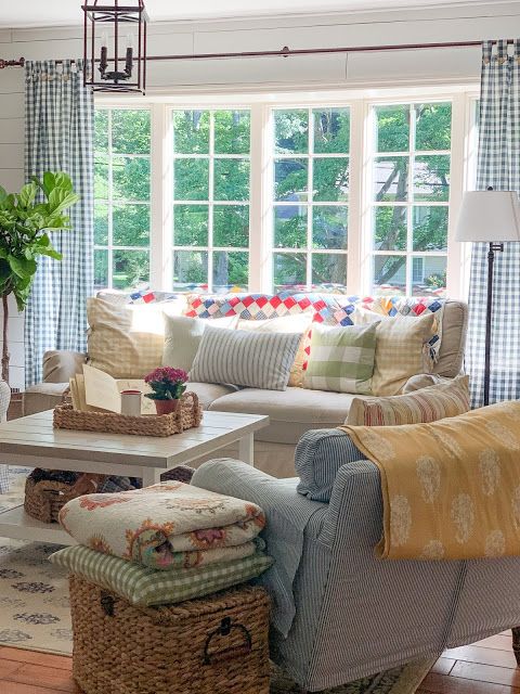 a living room filled with lots of furniture and pillows on top of a wooden floor