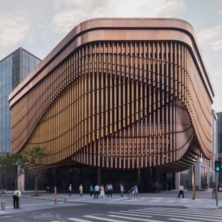 a large wooden building on the corner of a city street with people walking around it