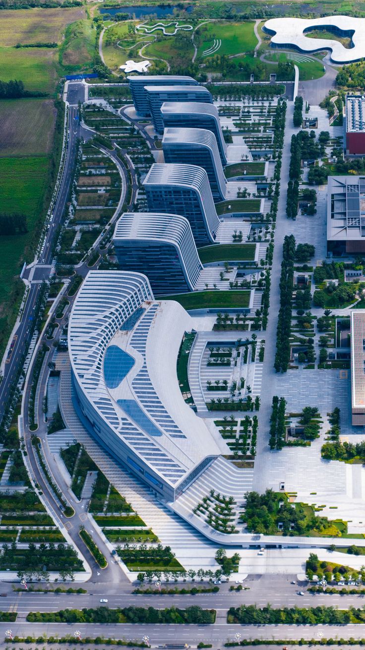 an aerial view of a large building with lots of trees and grass in front of it